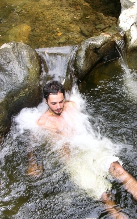 man massaging in running river water
