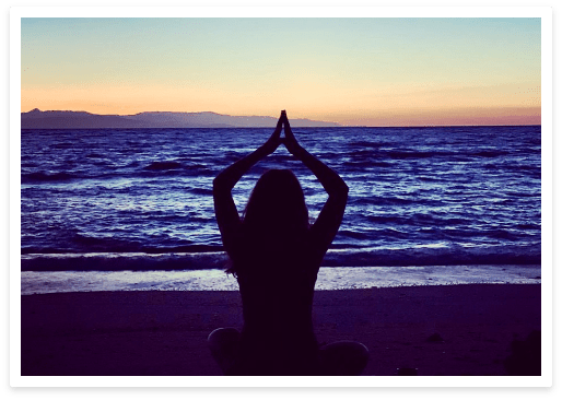 woman at beach in yoga pose during sunset